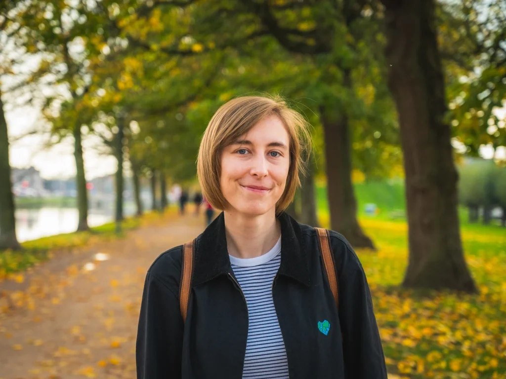 A girl smiling against an autumnal nature path