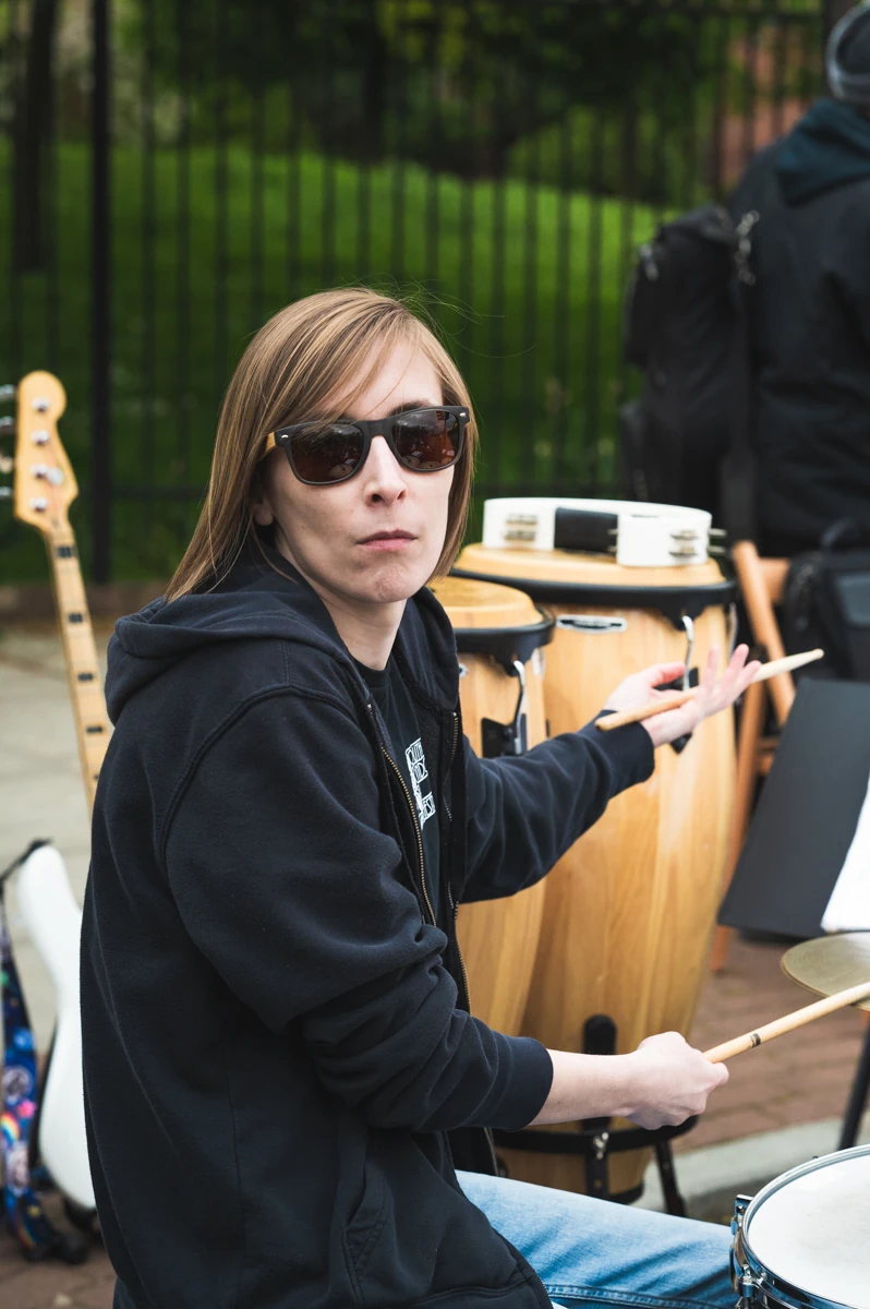 A jazz drummer shrugging at the camera
