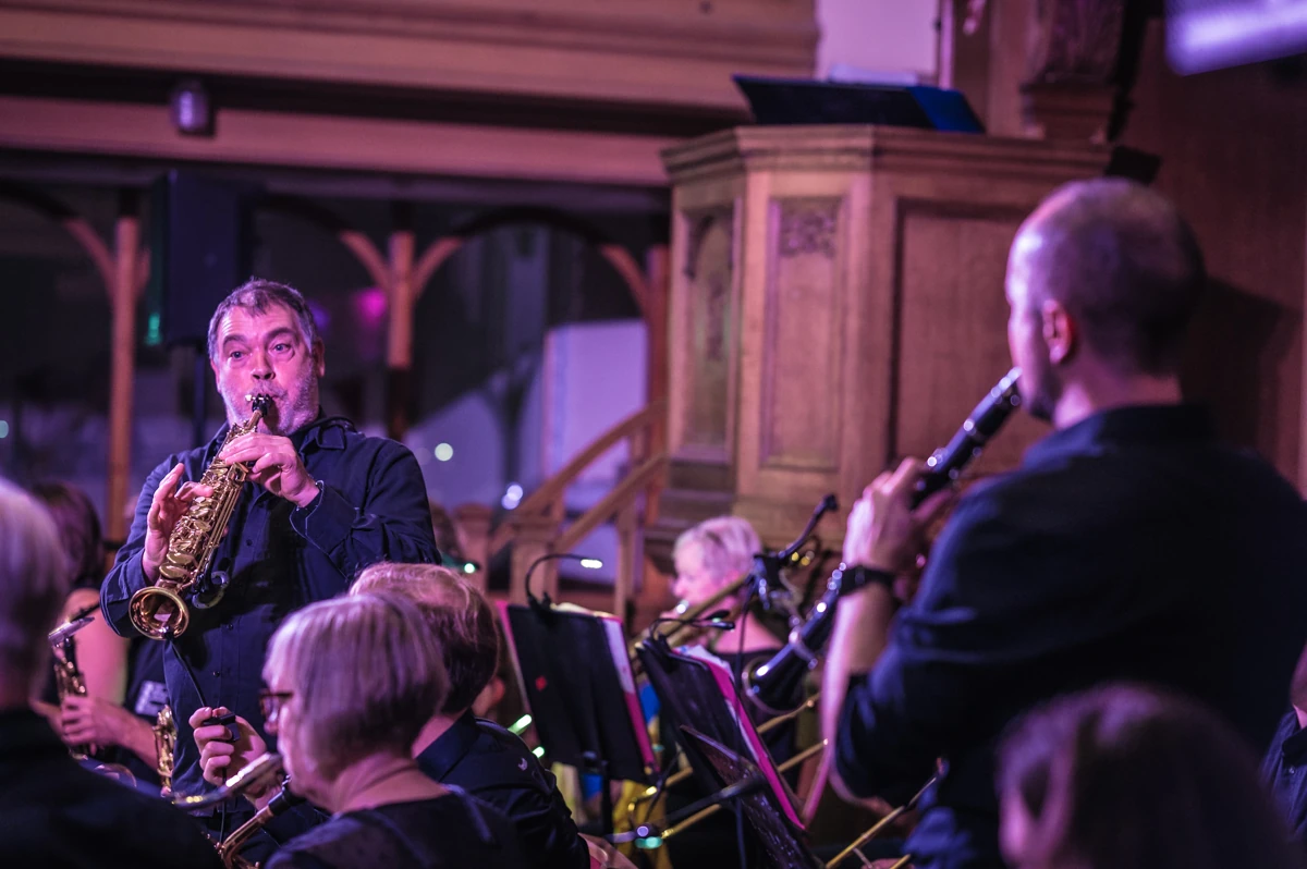 A jazz musician playing a soprano saxophone in a shared solo with a clarinet player