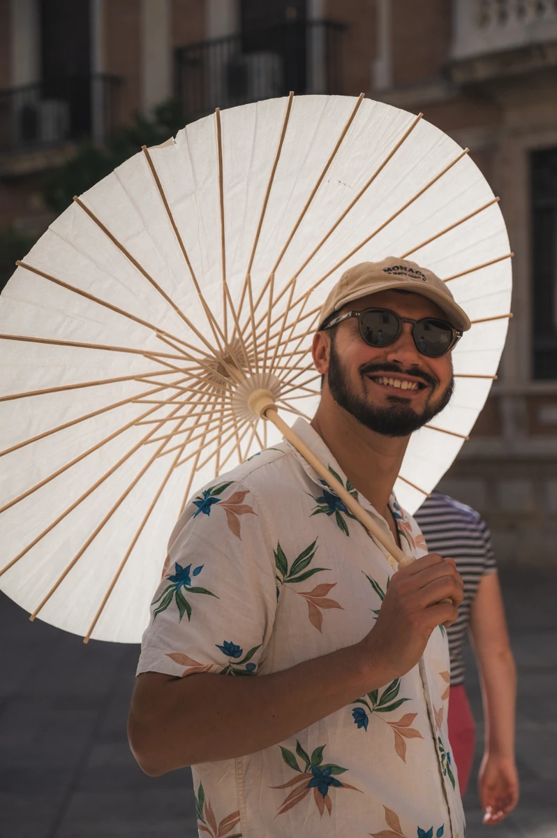 A man holding a parasol and smiling