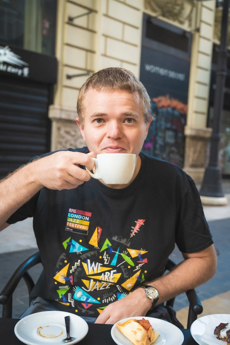 A man drinking coffee outdoors