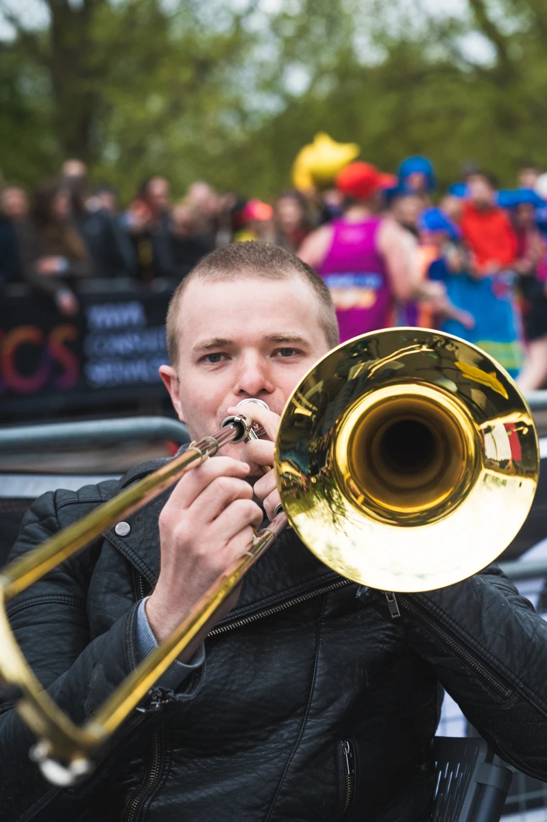 A jazz trombone player pointing his instrument at the camera