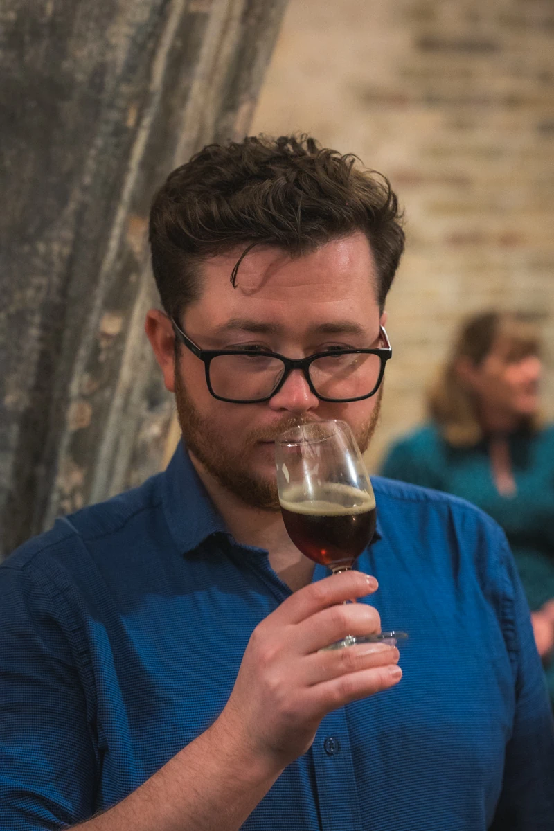 A man appreciating a small glass of beer