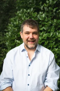 Man in a pale blue shirt smiling